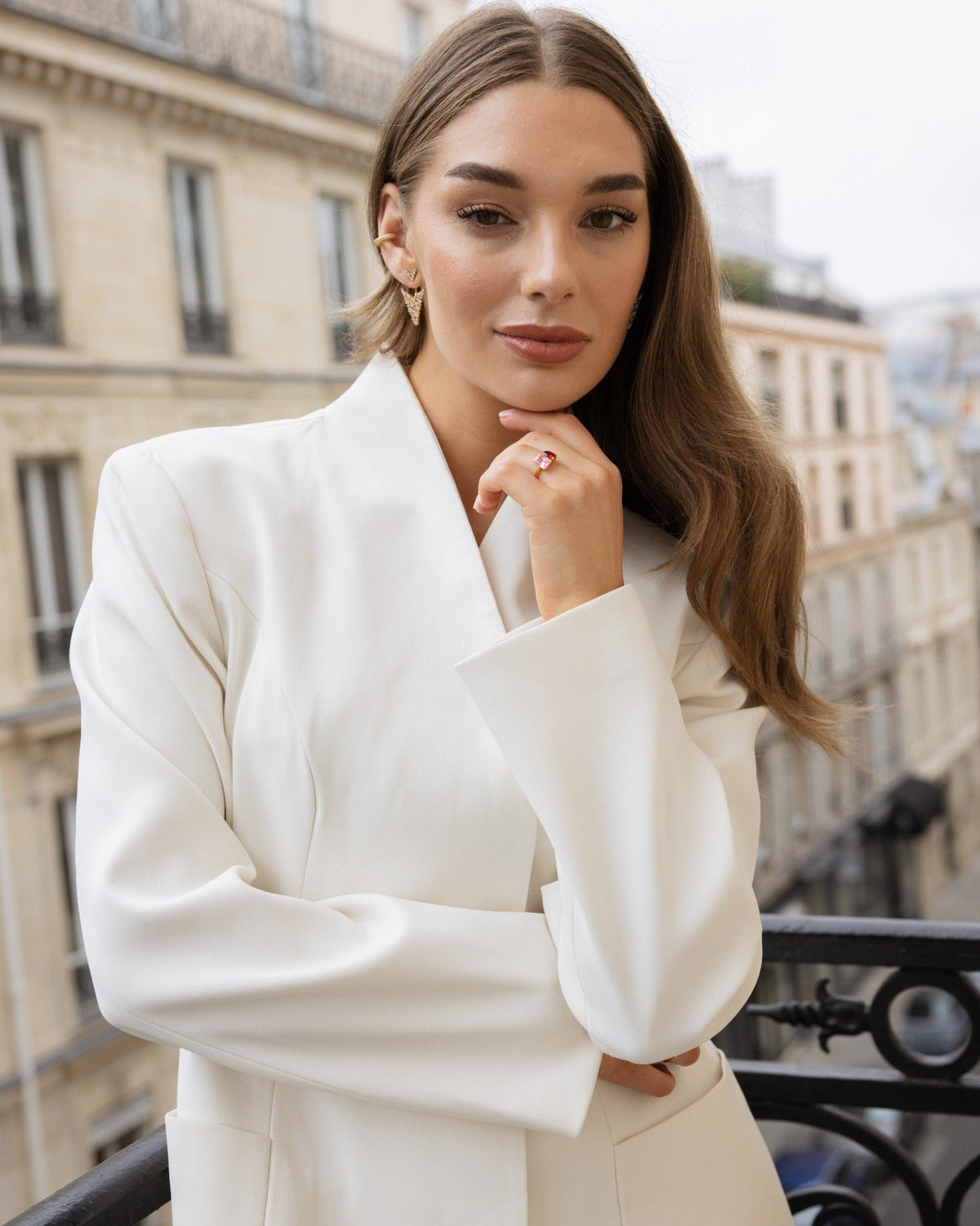 Melissa Gold earrings worn with a cream suit on a Paris balcony